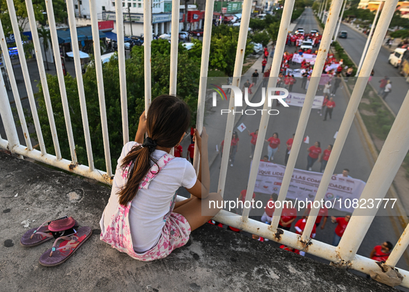 CANCUN, MEXICO - DECEMBER 1, 2023: 
A young girl observes participants of the World AIDS Day March in the center of Cancun, on December 1st,...