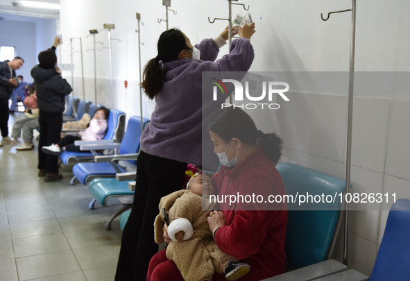 Sick children, accompanied by their parents, are waiting for treatment at the Department of Pediatrics of the People's Hospital in Fuyang Ci...