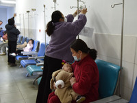 Sick children, accompanied by their parents, are waiting for treatment at the Department of Pediatrics of the People's Hospital in Fuyang Ci...