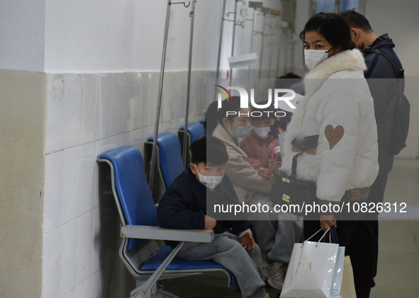 Sick children, accompanied by their parents, are waiting for treatment at the Department of Pediatrics of the People's Hospital in Fuyang Ci...