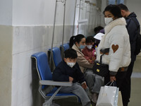 Sick children, accompanied by their parents, are waiting for treatment at the Department of Pediatrics of the People's Hospital in Fuyang Ci...