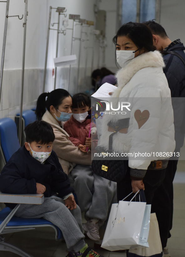 Sick children, accompanied by their parents, are waiting for treatment at the Department of Pediatrics of the People's Hospital in Fuyang Ci...