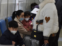 Sick children, accompanied by their parents, are waiting for treatment at the Department of Pediatrics of the People's Hospital in Fuyang Ci...