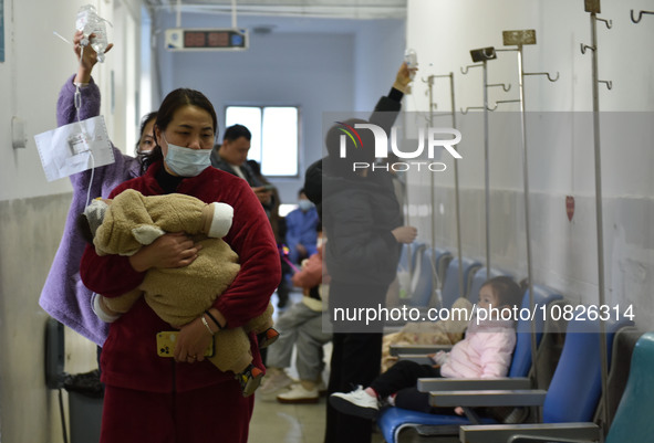 Sick children, accompanied by their parents, are waiting for treatment at the Department of Pediatrics of the People's Hospital in Fuyang Ci...