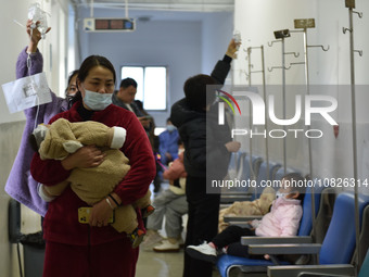 Sick children, accompanied by their parents, are waiting for treatment at the Department of Pediatrics of the People's Hospital in Fuyang Ci...