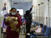 Sick children, accompanied by their parents, are waiting for treatment at the Department of Pediatrics of the People's Hospital in Fuyang Ci...