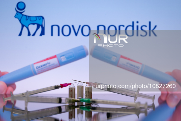 The Novo Nordisk pharmaceutical logo is being displayed on a screen alongside pills and a medical vial with a syringe in this photo illustra...