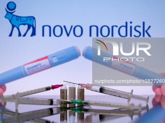 The Novo Nordisk pharmaceutical logo is being displayed on a screen alongside pills and a medical vial with a syringe in this photo illustra...