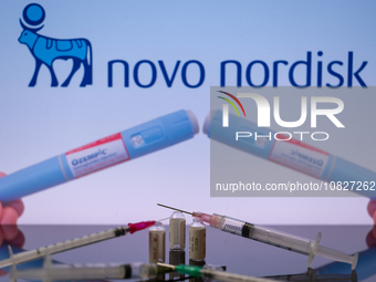 The Novo Nordisk pharmaceutical logo is being displayed on a screen alongside pills and a medical vial with a syringe in this photo illustra...