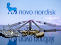 The Novo Nordisk pharmaceutical logo is being displayed on a screen alongside pills and a medical vial with a syringe in this photo illustra...