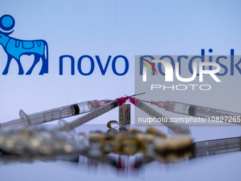 The Novo Nordisk pharmaceutical logo is being displayed on a screen alongside pills and a medical vial with a syringe in this photo illustra...