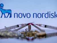 The Novo Nordisk pharmaceutical logo is being displayed on a screen alongside pills and a medical vial with a syringe in this photo illustra...