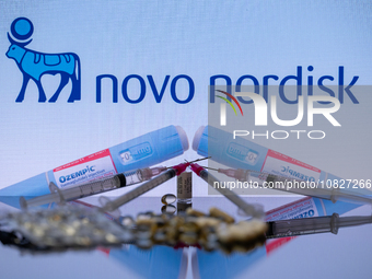 The Novo Nordisk pharmaceutical logo is being displayed on a screen alongside pills and a medical vial with a syringe in this photo illustra...