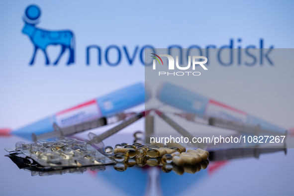 The Novo Nordisk pharmaceutical logo is being displayed on a screen alongside pills and a medical vial with a syringe in this photo illustra...