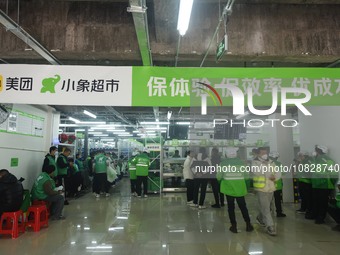 A Meituan employee is walking out of the front warehouse of Xiaoxiang Supermarket to deliver goods to customers in Hangzhou, Zhejiang Provin...