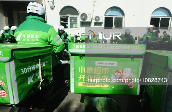 Employees of Meituan are waiting for delivery orders at the advance warehouse of Xiaoxiang supermarket in Hangzhou, Zhejiang Province, China...