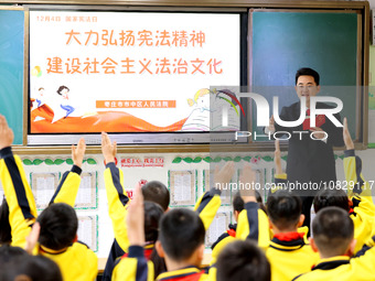 Judges are promoting constitutional knowledge to students at Wenhua Road Primary School in Zaozhuang, Shandong Province, China, on December...