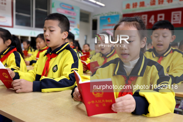 Primary school students are reading the Constitution in Zaozhuang, Shandong Province, China, on December 4, 2023. 