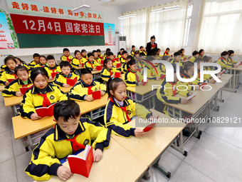 A judge is reading the Constitution with students at Wenlu Primary School in Zaozhuang, Shandong Province, China, on December 4, 2023. (