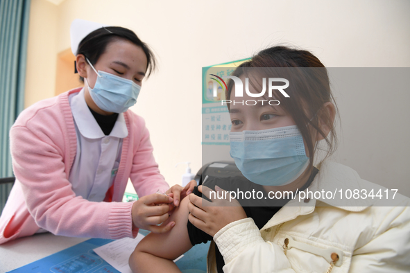 A medical worker is inoculating a citizen against influenza at a community health service center in Guiyang, Guizhou Province, China, on Dec...