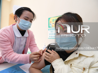 A medical worker is inoculating a citizen against influenza at a community health service center in Guiyang, Guizhou Province, China, on Dec...