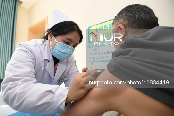 A medical worker is inoculating a citizen against influenza at a community health service center in Guiyang, Guizhou Province, China, on Dec...