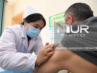 A medical worker is inoculating a citizen against influenza at a community health service center in Guiyang, Guizhou Province, China, on Dec...