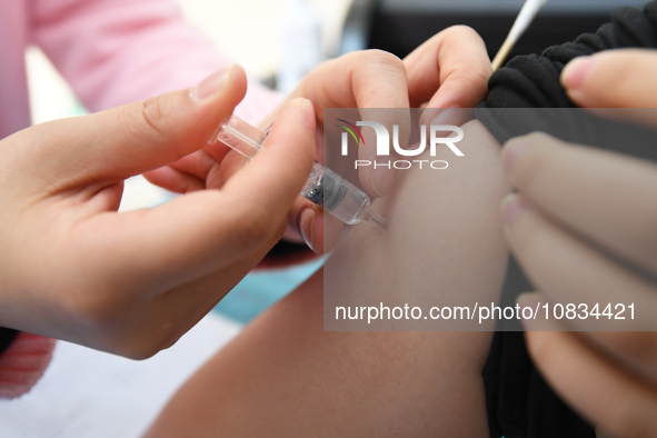 A medical worker is inoculating a citizen against influenza at a community health service center in Guiyang, Guizhou Province, China, on Dec...