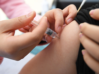 A medical worker is inoculating a citizen against influenza at a community health service center in Guiyang, Guizhou Province, China, on Dec...