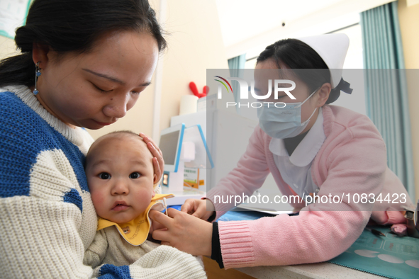 A medical worker is giving a child a flu vaccine at a community health service center in Guiyang, Guizhou Province, China, on December 7, 20...