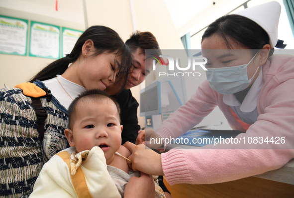 A medical worker is giving a child a flu vaccine at a community health service center in Guiyang, Guizhou Province, China, on December 7, 20...