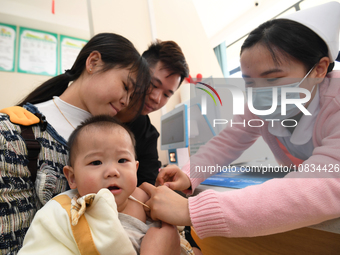 A medical worker is giving a child a flu vaccine at a community health service center in Guiyang, Guizhou Province, China, on December 7, 20...