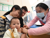 A medical worker is giving a child a flu vaccine at a community health service center in Guiyang, Guizhou Province, China, on December 7, 20...