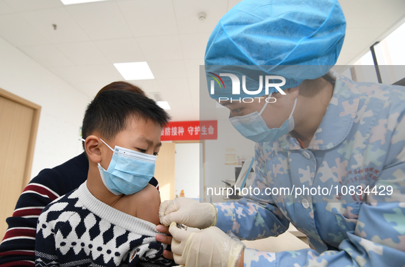 A medical worker is giving a child a flu vaccine at a community health service center in Guiyang, Guizhou Province, China, on December 7, 20...