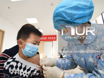 A medical worker is giving a child a flu vaccine at a community health service center in Guiyang, Guizhou Province, China, on December 7, 20...