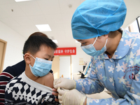 A medical worker is giving a child a flu vaccine at a community health service center in Guiyang, Guizhou Province, China, on December 7, 20...