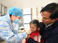 A medical worker is giving a child a flu vaccine at a community health service center in Guiyang, Guizhou Province, China, on December 7, 20...