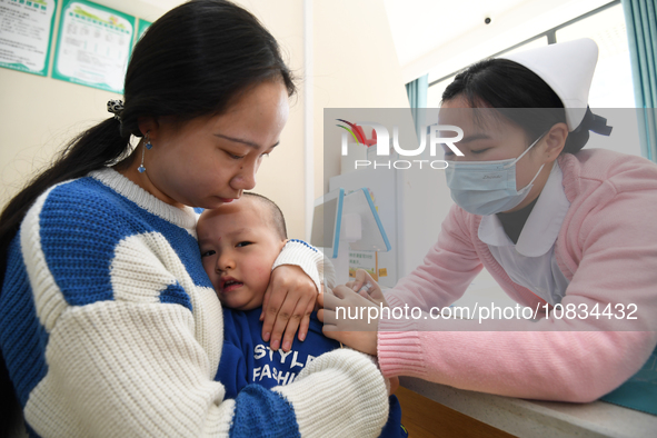 A medical worker is giving a child a flu vaccine at a community health service center in Guiyang, Guizhou Province, China, on December 7, 20...