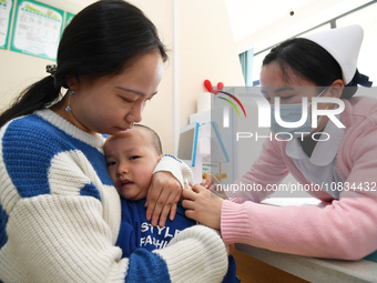 A medical worker is giving a child a flu vaccine at a community health service center in Guiyang, Guizhou Province, China, on December 7, 20...