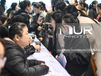 College student job seekers are communicating with representatives of employers at a college employment fair in Fuyang, Anhui Province, Chin...