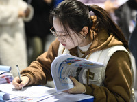 College student job seekers are communicating with representatives of employers at a college employment fair in Fuyang, Anhui Province, Chin...