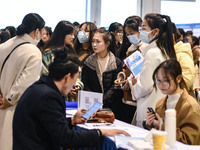 College student job seekers are communicating with representatives of employers at a college employment fair in Fuyang, Anhui Province, Chin...