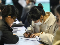 College student job seekers are communicating with representatives of employers at a college employment fair in Fuyang, Anhui Province, Chin...