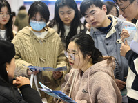 College student job seekers are communicating with representatives of employers at a college employment fair in Fuyang, Anhui Province, Chin...