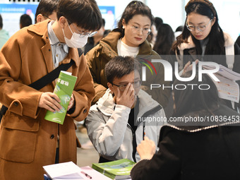 College student job seekers are communicating with representatives of employers at a college employment fair in Fuyang, Anhui Province, Chin...