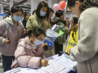 College student job seekers are communicating with representatives of employers at a college employment fair in Fuyang, Anhui Province, Chin...