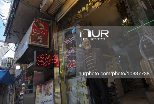 An elderly Iranian man is standing at the door of his restaurant in a bazaar within the flooded village of Imamzadeh Davood in the northwest...