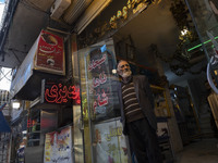 An elderly Iranian man is standing at the door of his restaurant in a bazaar within the flooded village of Imamzadeh Davood in the northwest...