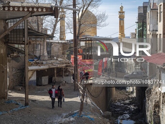 An Iranian couple is looking at destroyed shops as they walk along a collapsed street while visiting the flooded village of Imamzadeh Davood...