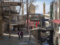 An Iranian couple is looking at destroyed shops as they walk along a collapsed street while visiting the flooded village of Imamzadeh Davood...